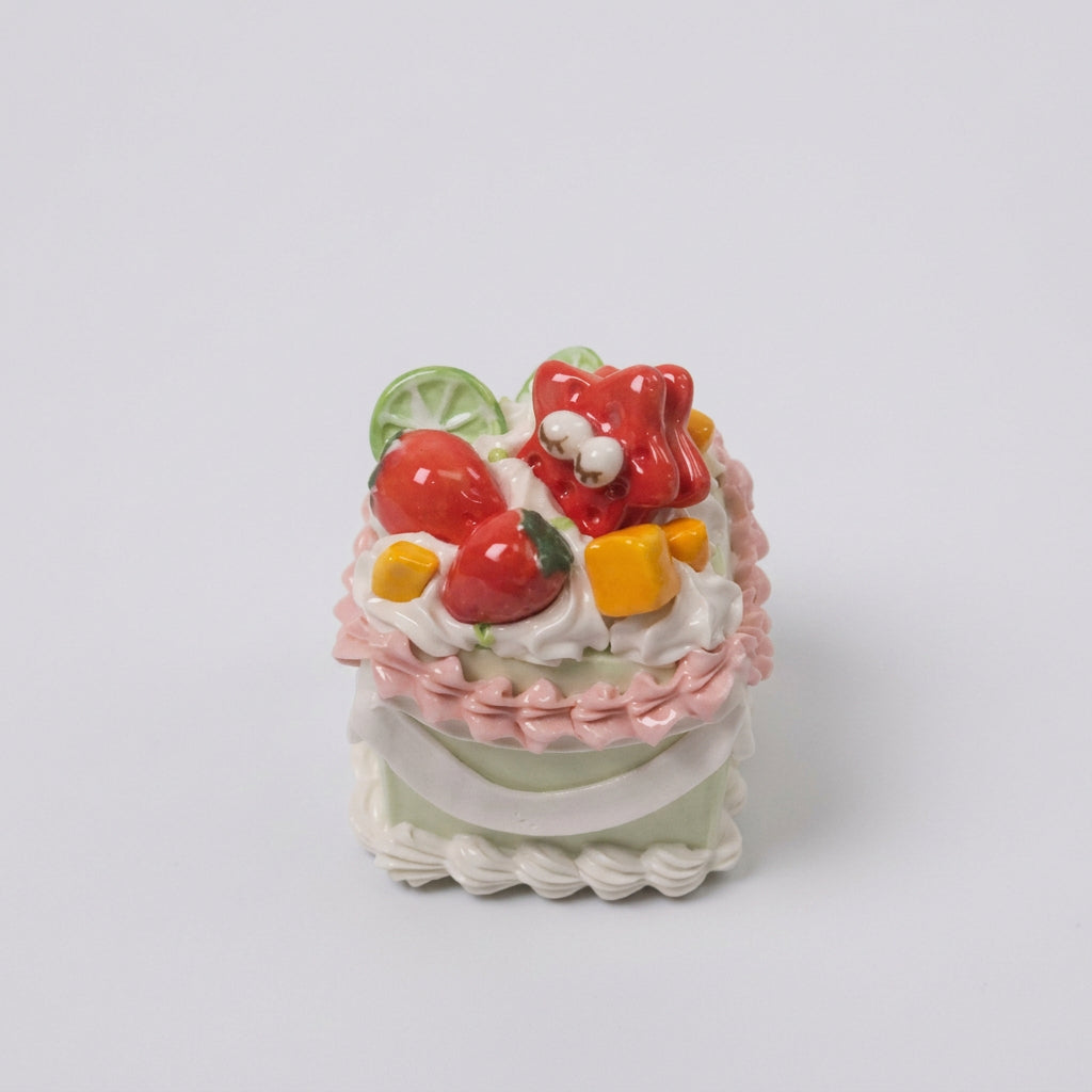 Close-up of the sleepy red star, strawberries and white cream swirls on Clayying's ceramic cake.