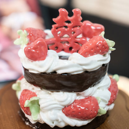Decorative cake with strawberries and a red decorative element on top
