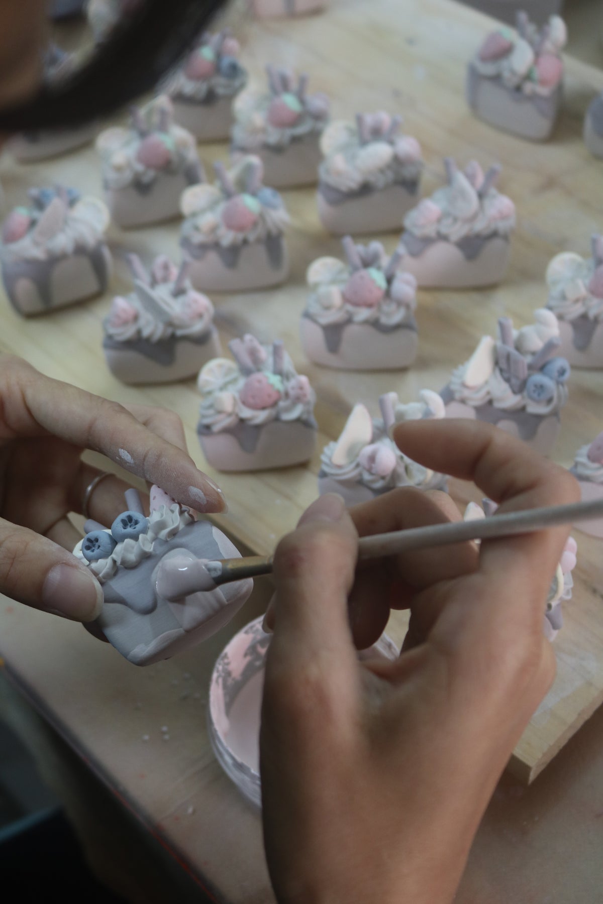 Hand finishing a small ceramic cake in the Clayying studio